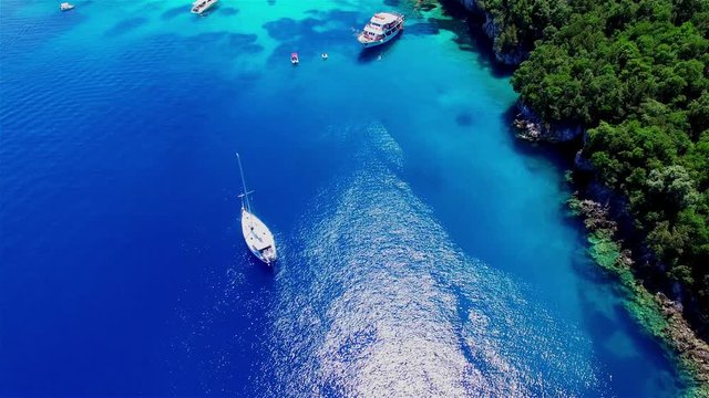 Tropical Ionian Greece island aerial 4k travel video. Yacht boat on blue water in ocean sea harbor bay, forest coast seashore, marina