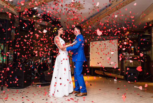 Red Confetti Falls Around Dancing Wedding Couple