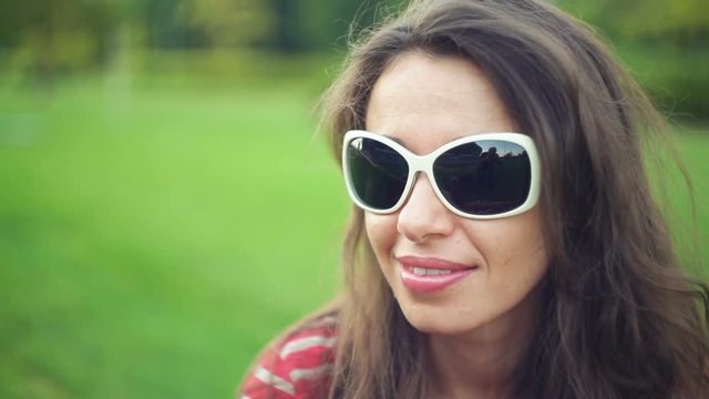 beautiful woman in sunglasses at the summer park