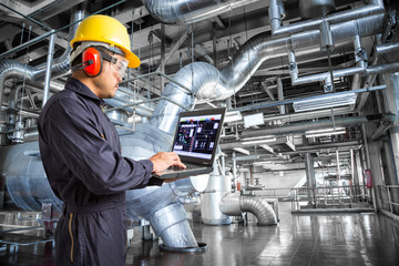 Engineer using laptop computer in the factory