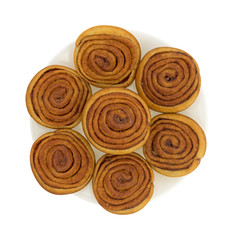 Pecan sweet rolls on a plate top view atop a white background.