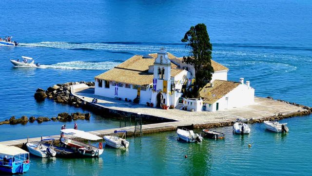 Vlacherna Monastery from Kanoni, boats moored on dock boat station pier. Greece Corfu marina harbor 4k video