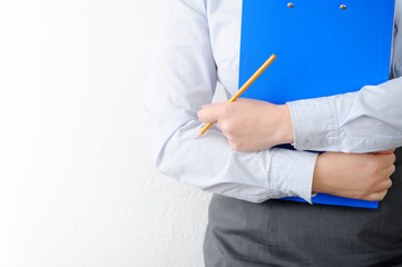 Business woman close up. Folder and pencil in hand.