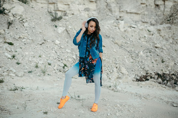Young woman with headphones posing and dancing
