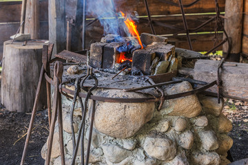 Leningrad region, Podporozhsky District, Russia &ndash; June 26, 2016: Fire, live coals and blacksmith's tools  - The village of Upper Mandrogi  is a reproduction of a traditional Russian village.