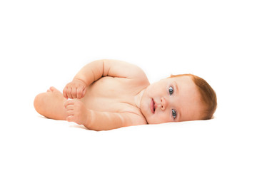 Funny little baby lying down on a blanket . Newborn child relaxing in bed. Nursery for young...