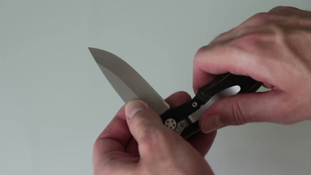 Man opens penknife