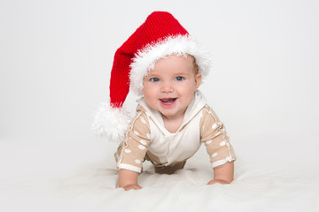 Photos of smiling young baby in a Santa Claus hat on white blanket


