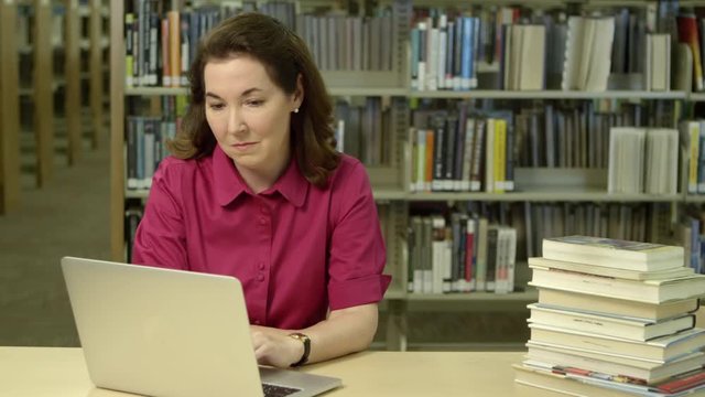 Portrait of woman using laptop in the library