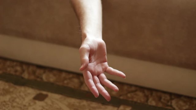 Man's hanging and insensible hand with medicine