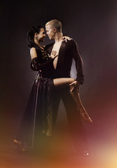 Dancing young couple on a black background.