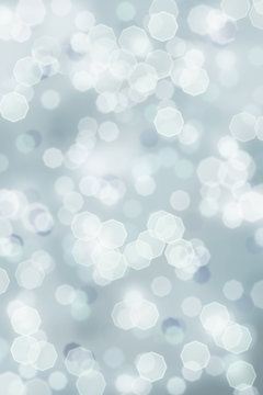 A blue grey bright sparkly abstract background of retro tinted Christmas holiday bokeh lights.