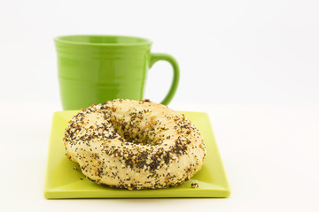 Everything bagel with fresh coffee in green mug