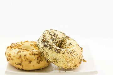 Two specialty bagels placed on white plate