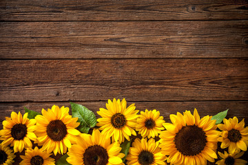 Naklejka premium Sunflowers on wooden background