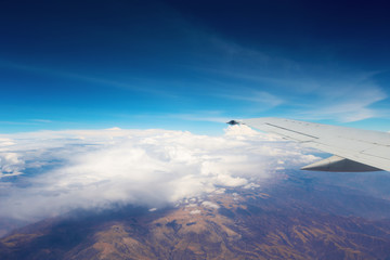 Obraz premium Aircraft wing flying over clouds.