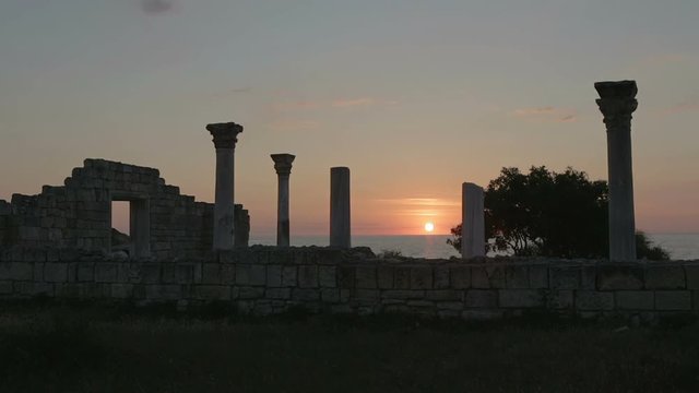 Ancient Greek basilica and marble columns in Chersonesus Taurica on the sunset background.