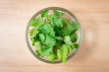 bowl of  coriander leaf on a wooden block
