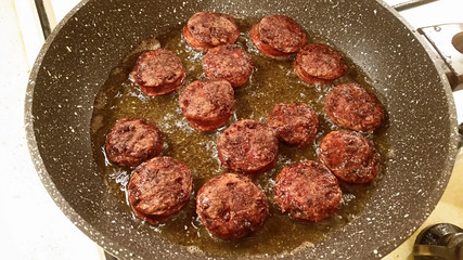 Fragrant smoked sausage with spices fried in a pan