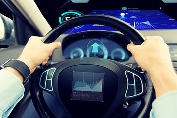 close up of man driving car with graph on screen