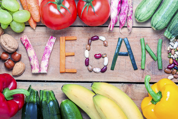 vegan word on wood background and vegetable - food