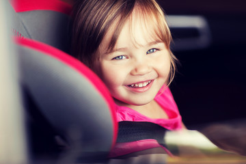 happy little girl sitting in baby car seat