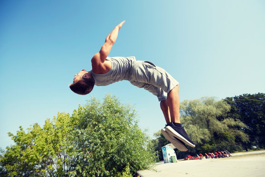 sporty young man jumping in summer park
