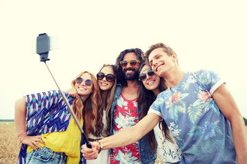 Fototapeta premium hippie friends with smartphone on selfie stick