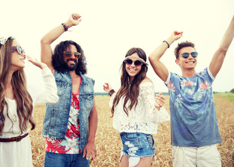 happy young hippie friends dancing outdoors