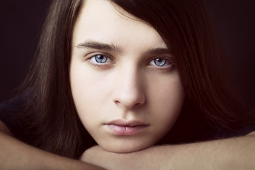 A portrait of a handsome teenager on dark background. Vintage style