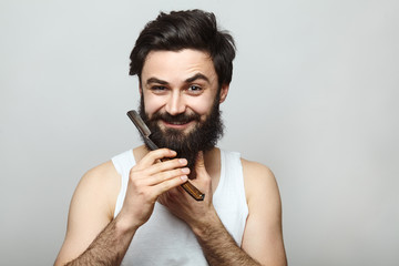 Handsome young man shaving his face