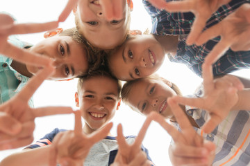 group of happy children showing v sign in circle