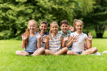 Fototapeta premium group of happy kids waving hands outdoors