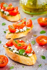 bruschetta with pesto  sauce, feta cheese, tomatoes and basil
