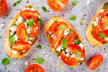 bruschetta with pesto  sauce, feta cheese, tomatoes and basil