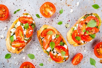 bruschetta with pesto  sauce, feta cheese, tomatoes and basil