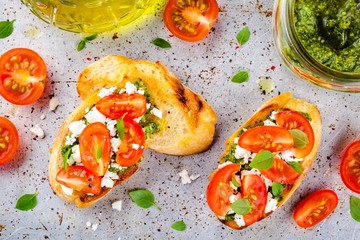 bruschetta with pesto  sauce, feta cheese, tomatoes and basil