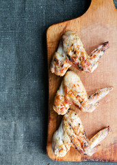 Grilled Chicken wings on a wooden board top view