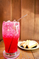 Red soda water with Sandwich on wood background
