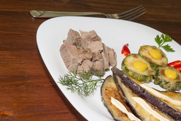 Dinner plate with meat and vegetables on wooden table