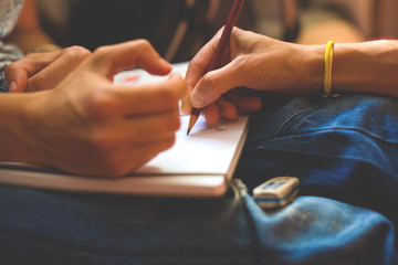 Obraz premium A person draws with a pencil in a notebook.