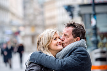 Fototapeta premium Senior couple on a walk in city centre. Winter
