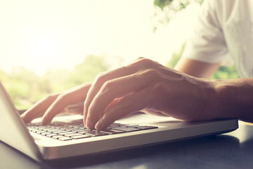 programmer's hand typing with laptop. focus on his finger.