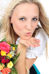 Obraz na płótnie Canvas blonde Frau im Dirndl mit einem Blumenstrauß