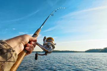 Selbstklebende Fototapete Angeln fishing on a lake at sunrise