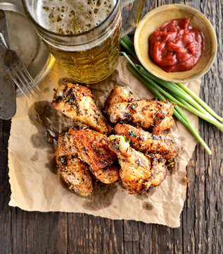 fried wings and beer on a wooden background