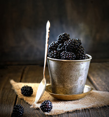 Fototapeta na wymiar Fresh blackberries in a bucket on a wooden background. rustic style