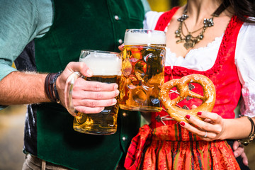 Hände, die Bier und Bretzeln halten, Ausschnitt bayrische Tracht

Hands holding Beer and...