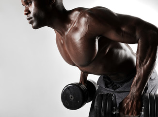 Fototapeta na wymiar Young man working out with heavy dumbbells