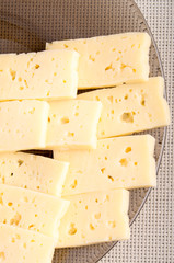 Group slices dry hard yellow cheese on a plate